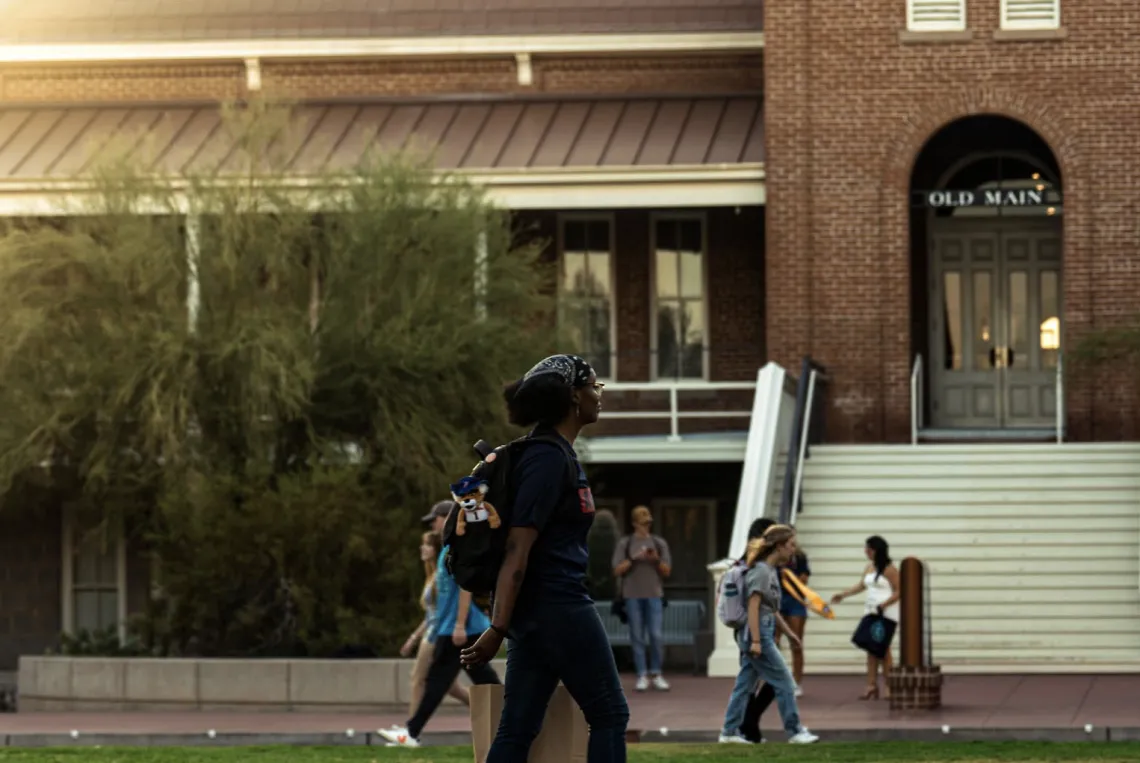 Students walking on campus, in front of Old Main